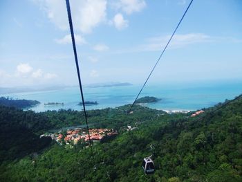 Overhead cable car over sea against sky