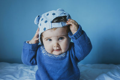 Cute girl with cap sitting on bed