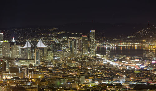 Illuminated cityscape against sky at night