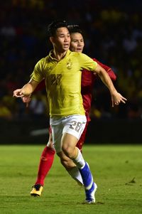 Full length of a boy playing soccer on field