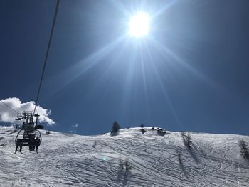 Low angle view of ski lift against sky during winter