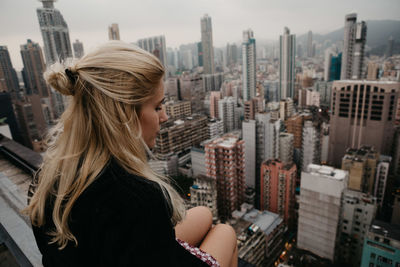 Woman sitting against cityscape