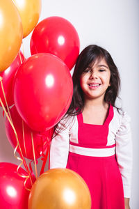 Portrait of a smiling girl holding balloons