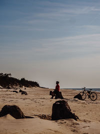 People riding horse on beach against sky