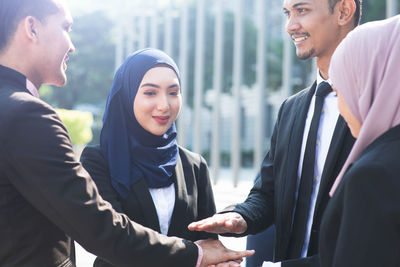 Young man and woman standing in city