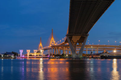 Illuminated bridge over river at night