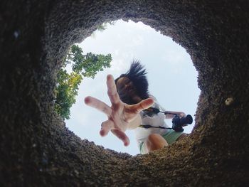 Woman sitting on tree trunk