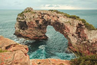 Rock formations in sea against sky