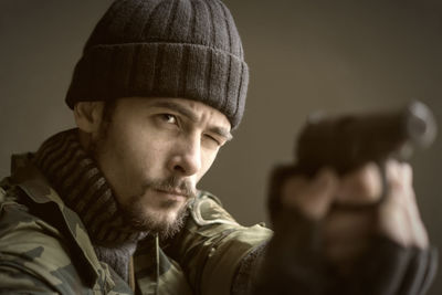 Close-up of army soldier aiming with handgun