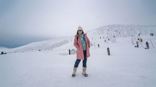 Rear view of woman walking on snow covered landscape