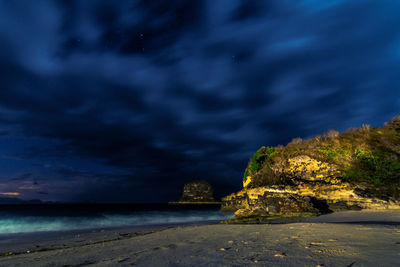 Scenic view of beach against cloudy sky