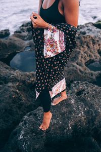 Low section of woman standing on rock