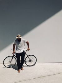 Man on bicycle against wall