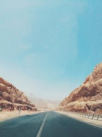 Road leading towards mountain against sky