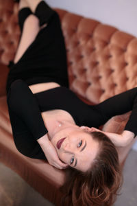 Portrait of young woman standing against wall