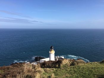 Lighthouse by sea against sky