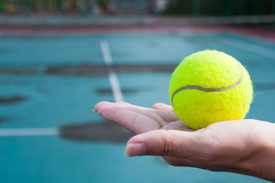 Close-up of woman hand holding tennis ball
