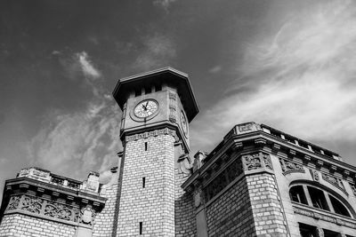 Low angle view of clock tower against cloudy sky