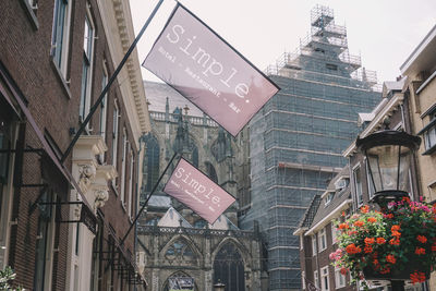 Low angle view of road sign against buildings in city
