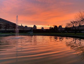 Reflection of building in river during sunset