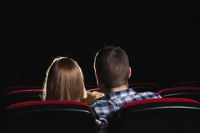 Rear view of a couple sitting on chairs