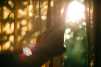 Close-up of person looking out window