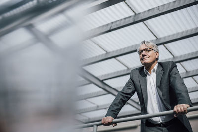 Senior businessman standing at railing