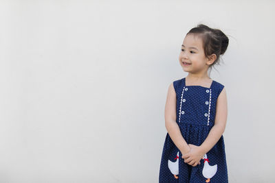 Cute girl standing against wall