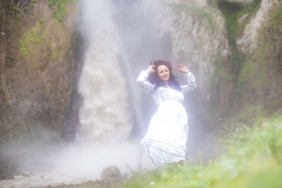 Woman standing in waterfall