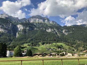 Scenic view of green landscape and mountains against sky