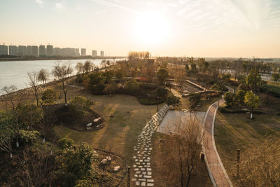 High angle view of river and buildings against sky at sunset