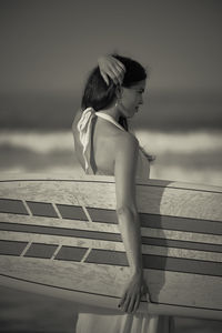 Side view of young woman standing on ground