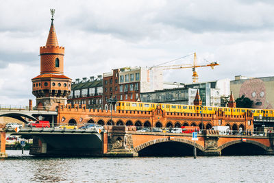 Bridge over river against cloudy sky