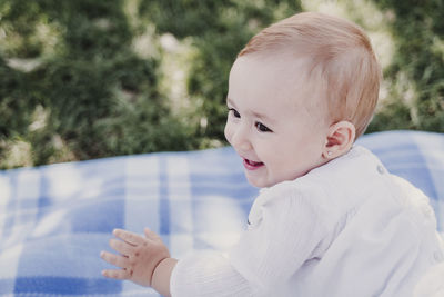 Close-up of cute baby girl on picnic blanket