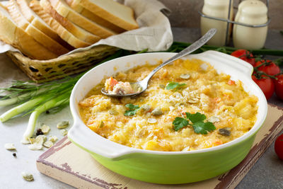 Casserole crumble with red fish, white bread and cheese on stone or slate background. 