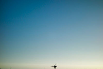 Low angle view of windmill against clear blue sky