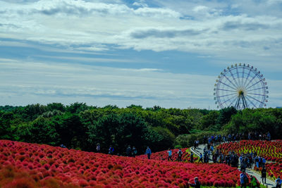 People in amusement park against sky