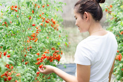 Side view of woman holding plants