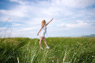 Woman standing on field against sky