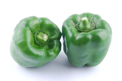 Close-up of green bell peppers against white background