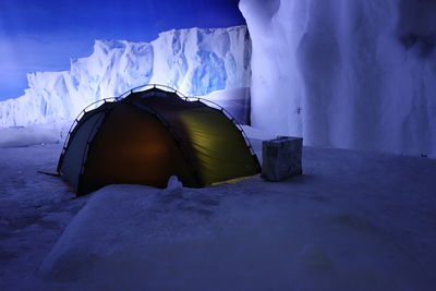 Tent on snowcapped field at night