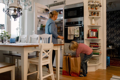 Grandson helping grandmother in household chores