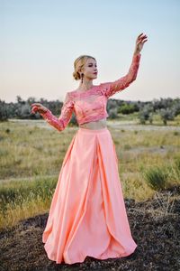 Beautiful young woman standing on land against clear sky