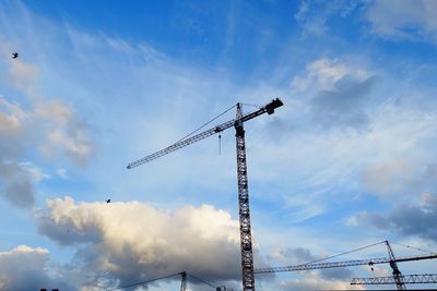 Low angle view of crane against sky