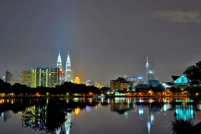 Illuminated buildings in city against sky at night