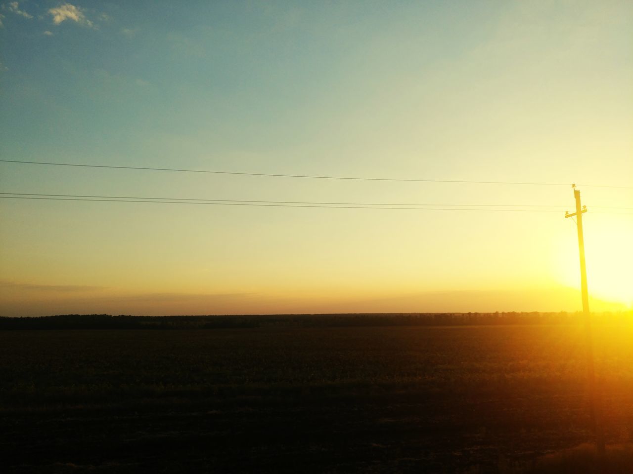 sky, sunset, environment, cable, tranquil scene, technology, beauty in nature, tranquility, electricity, scenics - nature, power line, landscape, nature, field, no people, land, electricity pylon, connection, sun, orange color, power supply, outdoors, telephone line