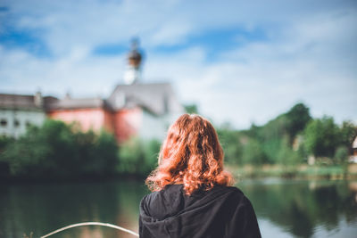 Rear view of woman in lake against sky