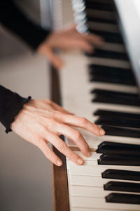 Cropped hands playing piano