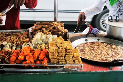 Midsection of people having food at stall