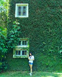 Full length of woman standing by building